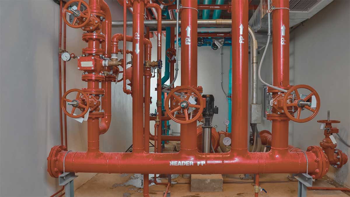 Close-up of an active fire sprinkler head releasing water during fire sprinkler maintenance. 