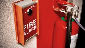 Fire alarm pull station next to a fire extinguisher