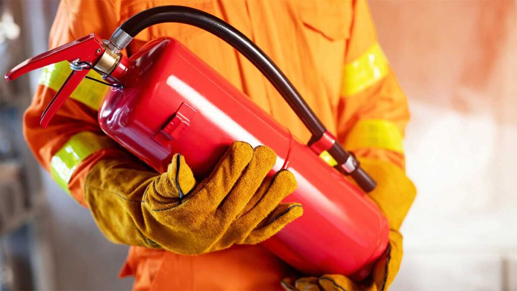  Firefighter holding a red fire extinguisher
