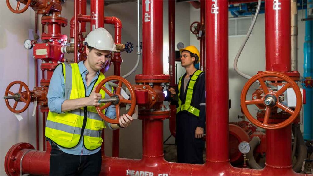 Technicians inspecting commercial fire sprinkler valves.