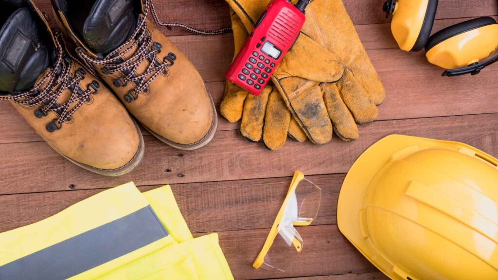 Protective safety gear and equipment laid out on a wooden surface.