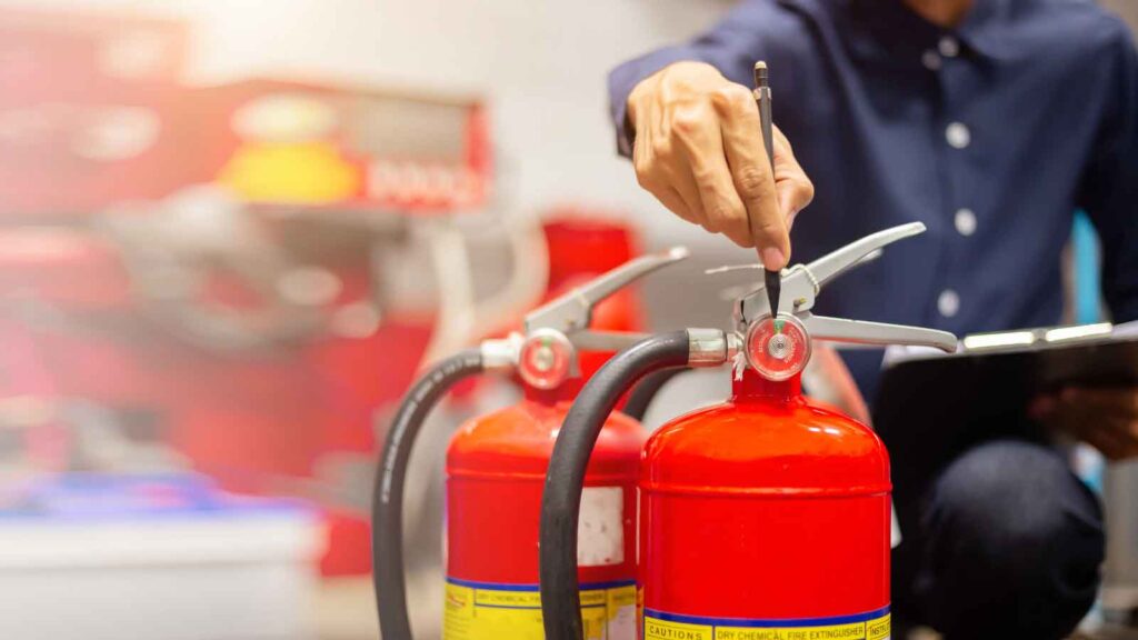 Technician inspecting and testing fire extinguishers.