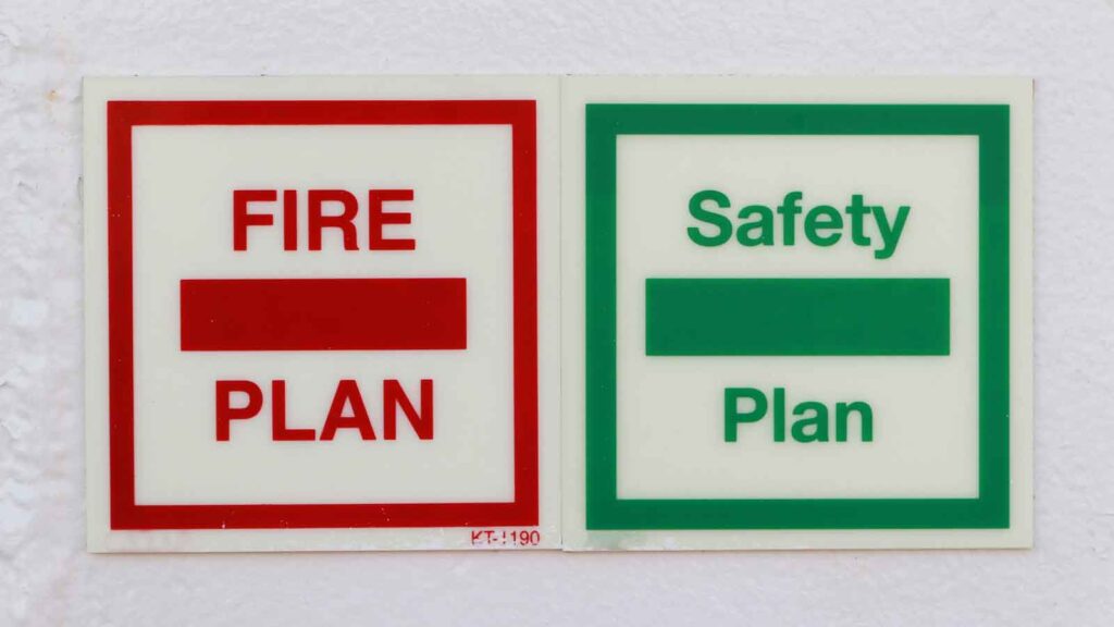 Fire and safety plan signs displayed on a wall.
