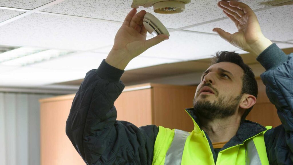 Technician installing a smoke detector