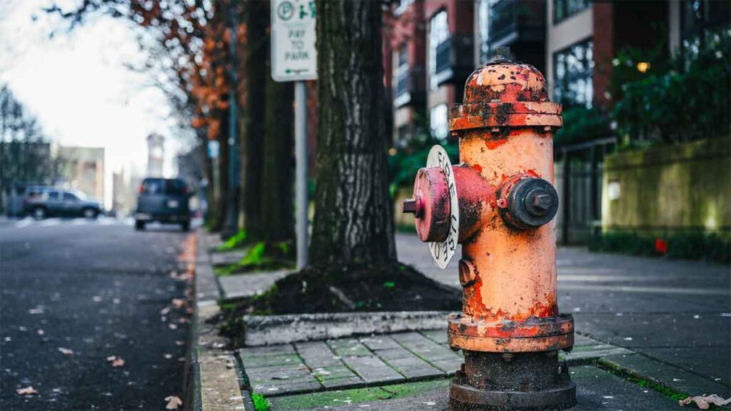 Rusty and corroded fire hydrant on a city street.