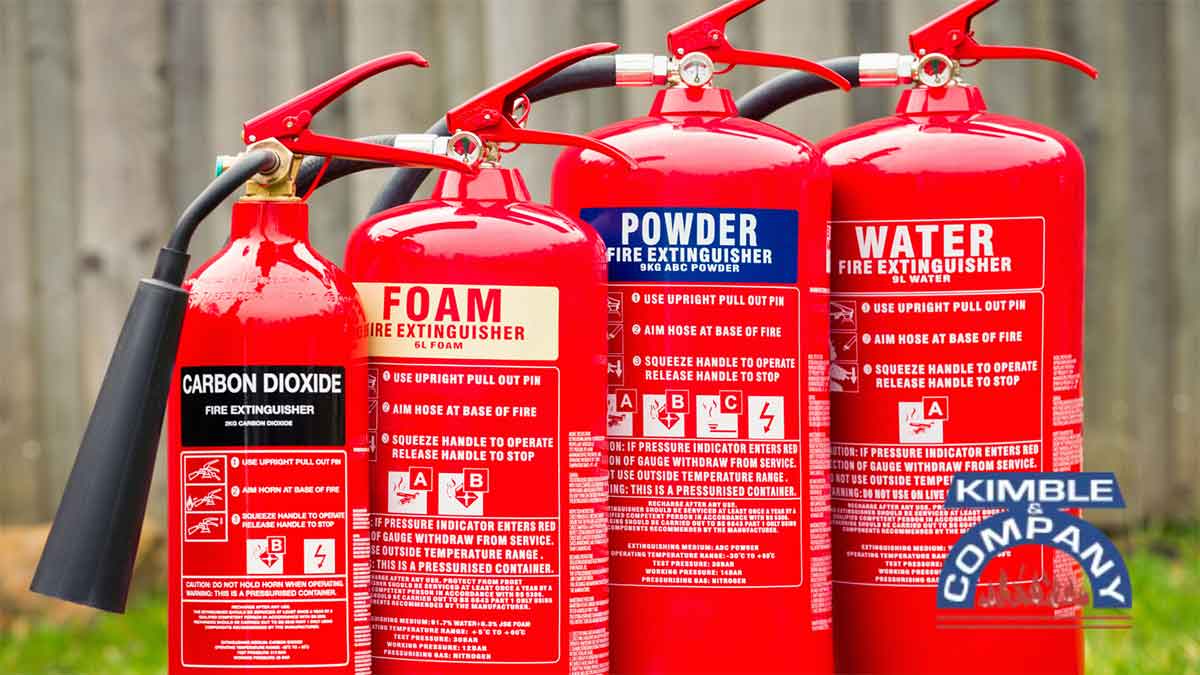 Different types of fire extinguishers lined up outdoors.