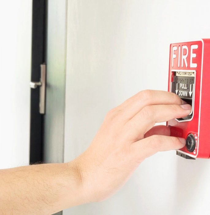 man-is-reaching-his-hand-push-fire-alarm-hand-station1 man is reaching his hand push fire alarm hand station